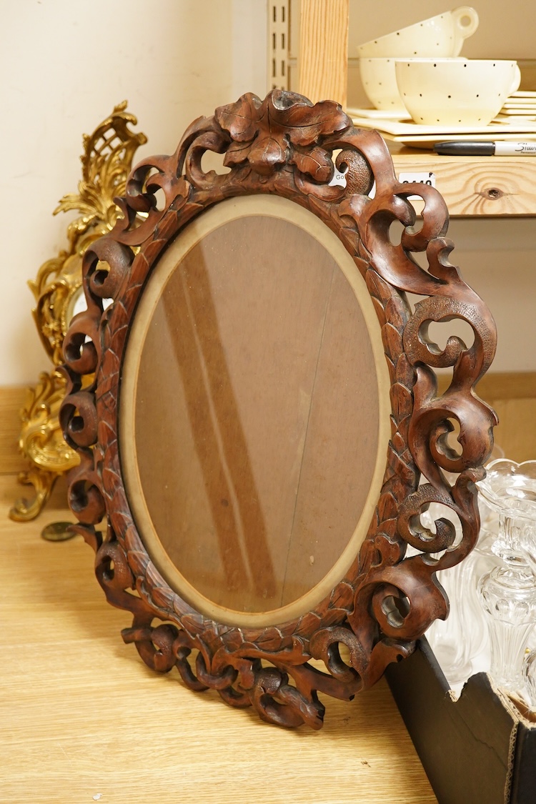 An oval carved wood mirror, 53cm high
